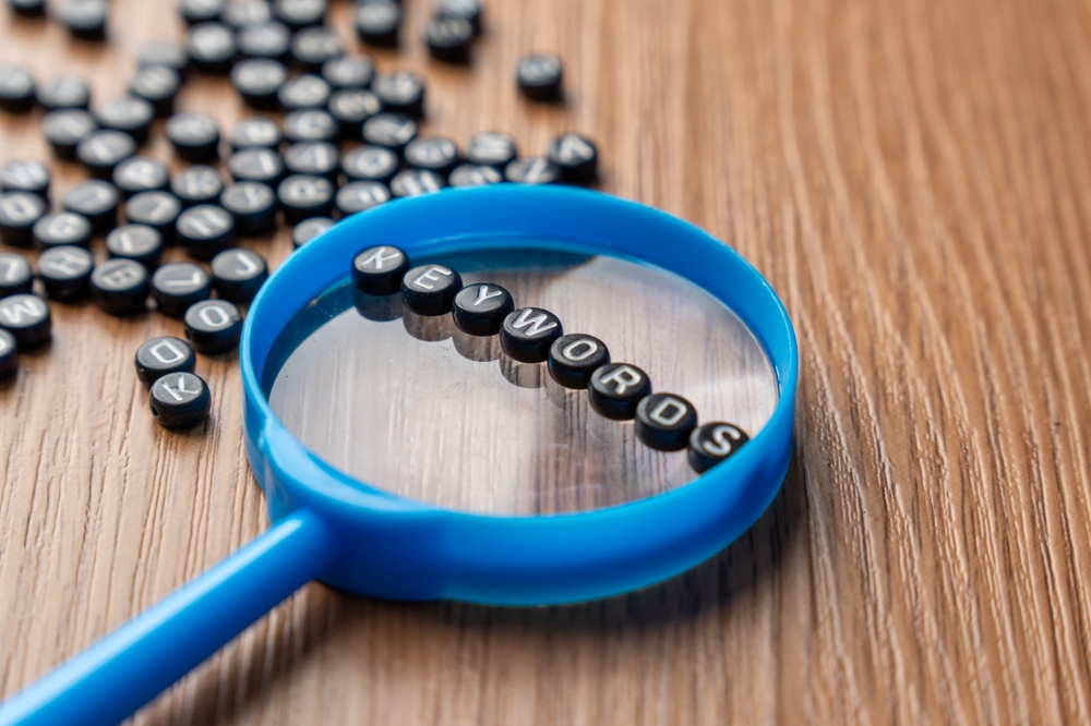 A,Blue,Magnifying,Glass,With,Alphabet,Beads,That,Spell,Out